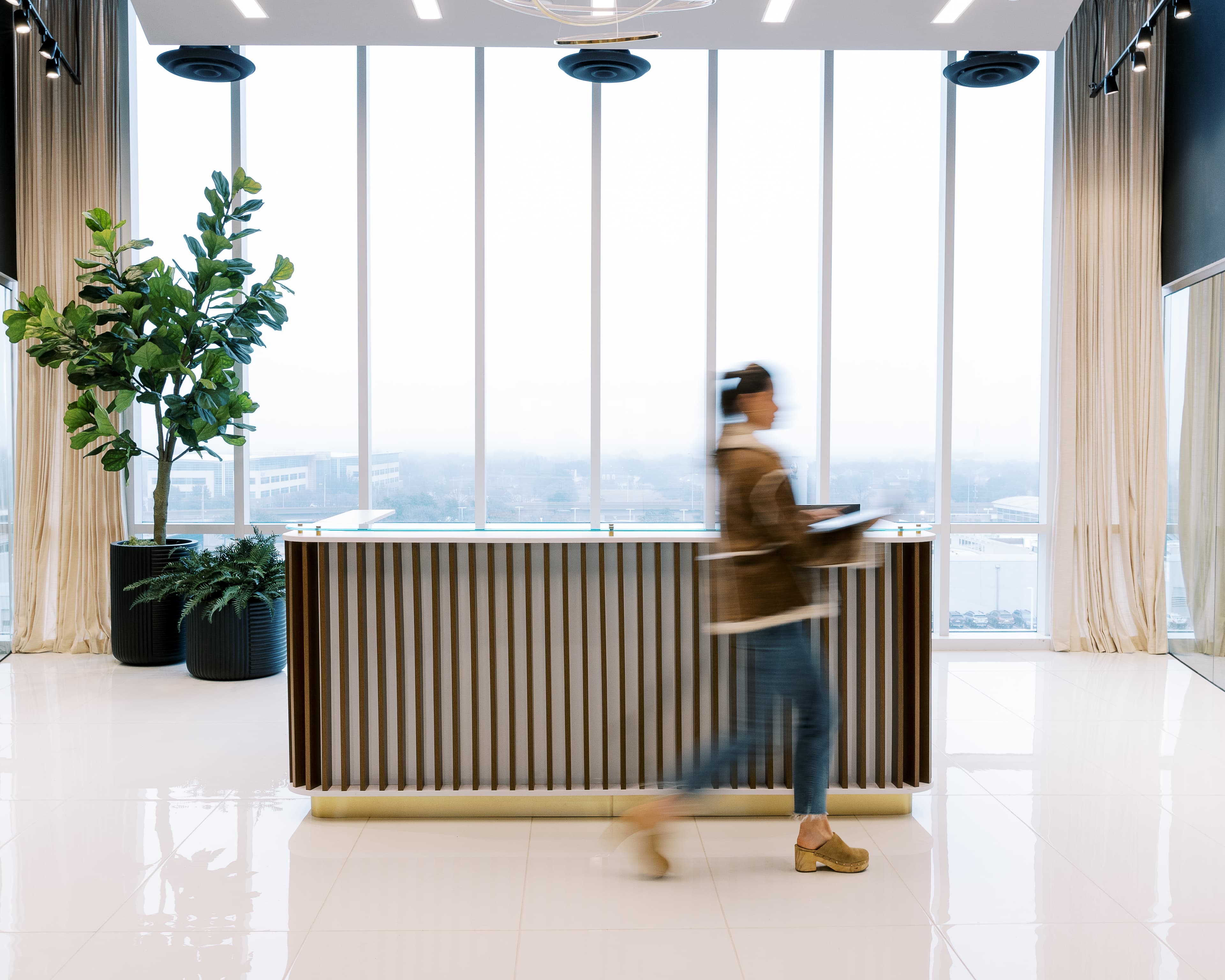 Woman walking in front of reception desk at West Plano / Willow Bend