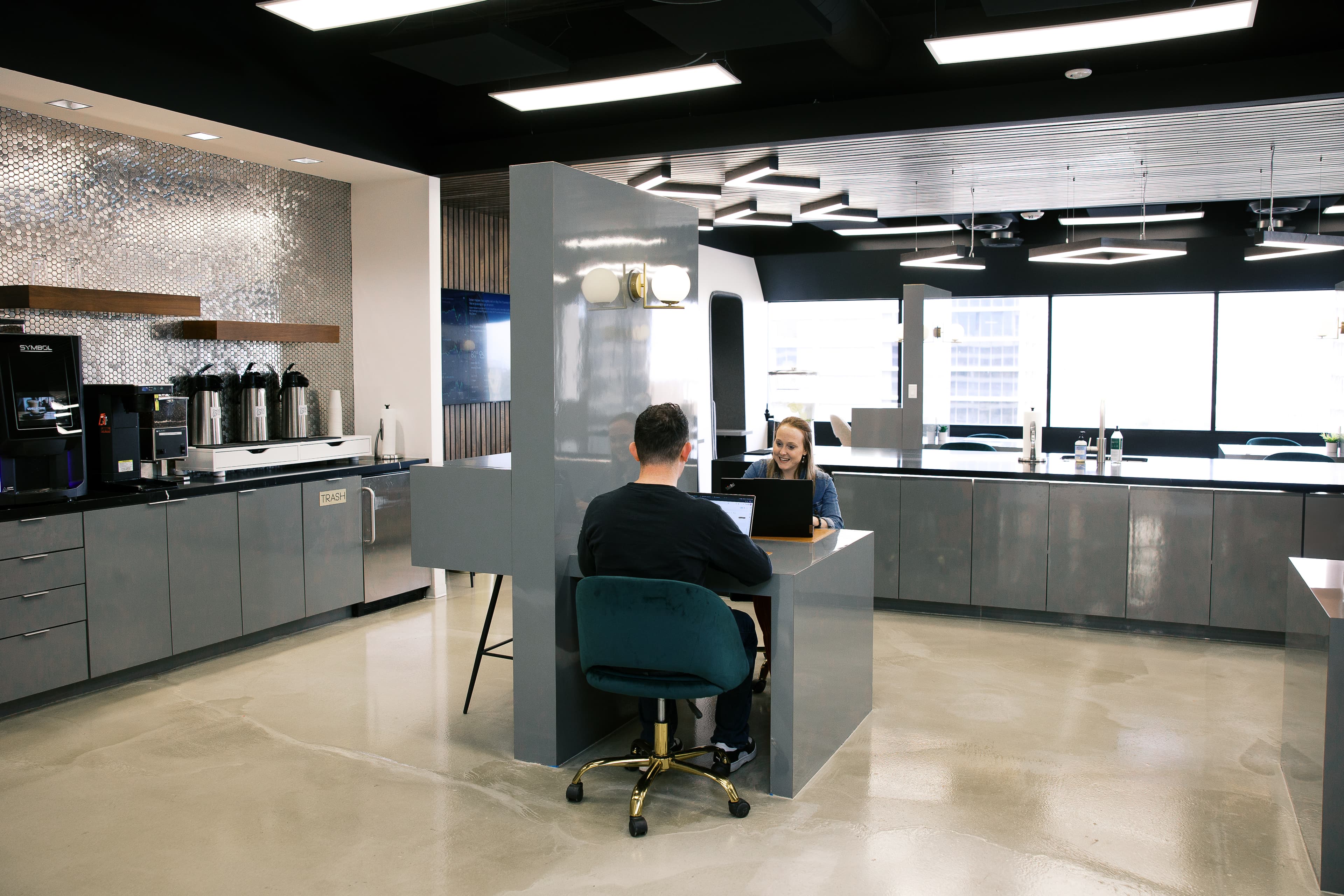 Two people working in the coffee lounge at Lucid Private Offices - Mockingbird