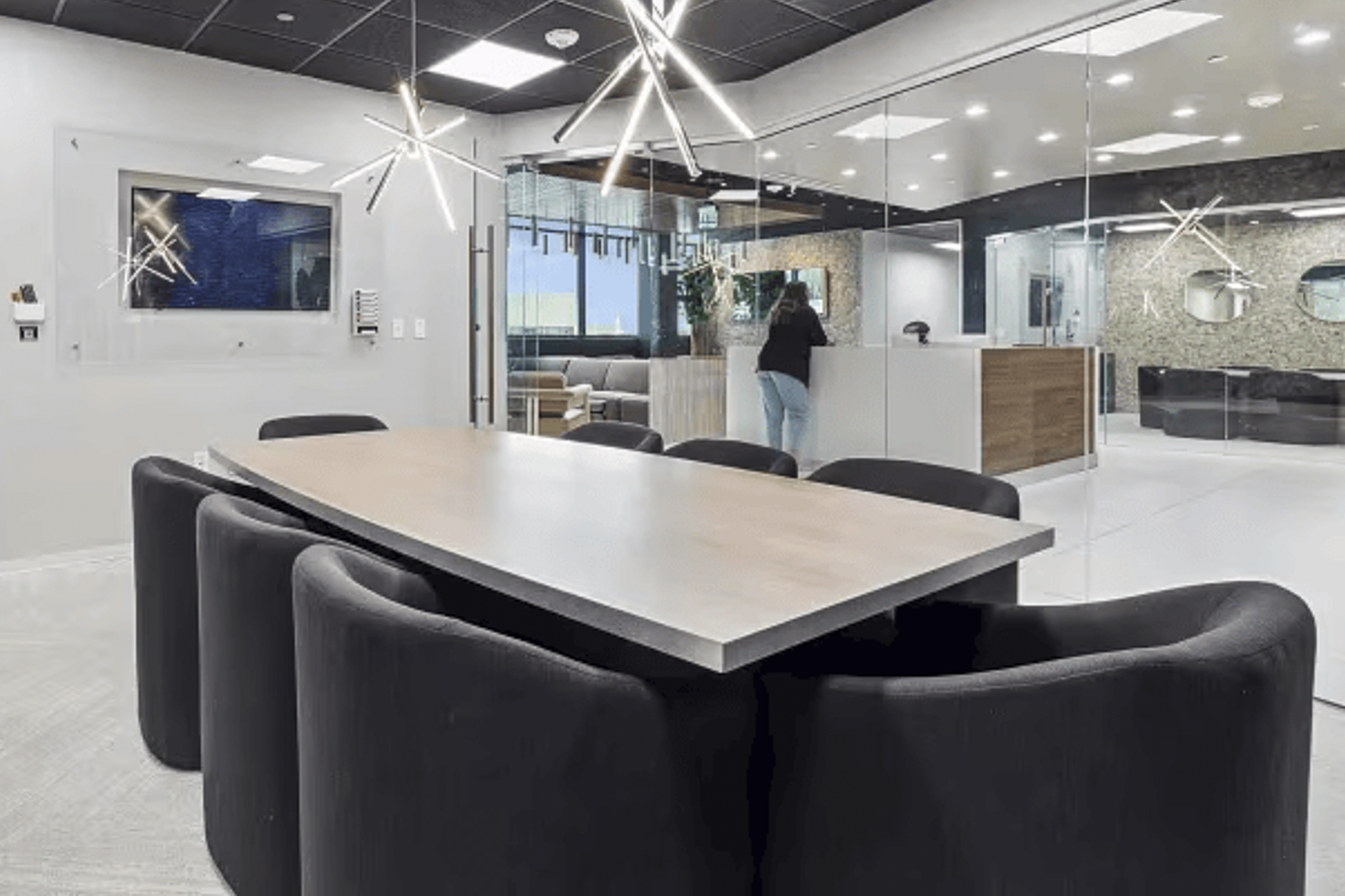 Library meeting room with bookshelves, velvet lounge chairs, and arc floor lamp