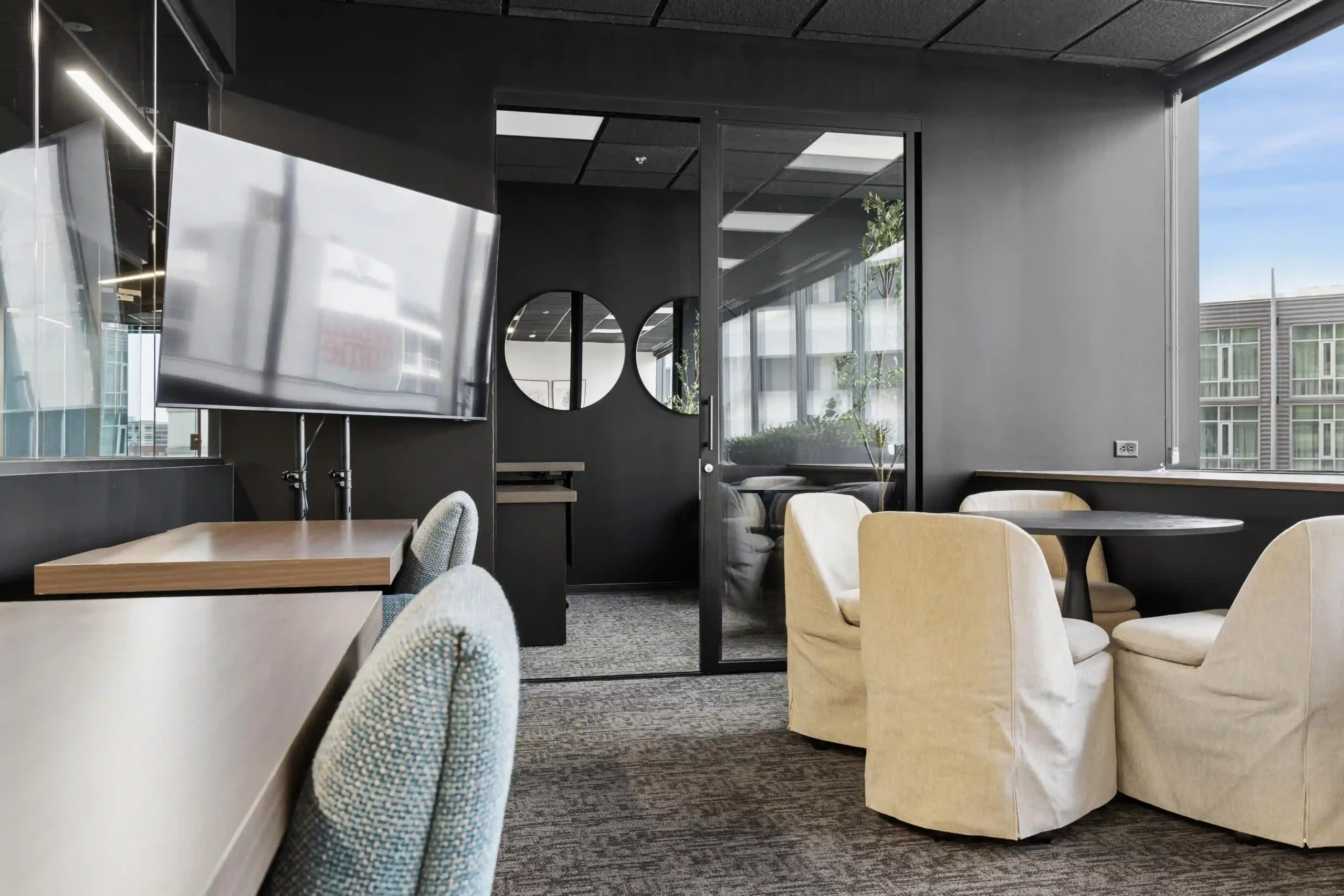 Breakout lounge with TV and armchairs at Lucid Private Offices Nashville