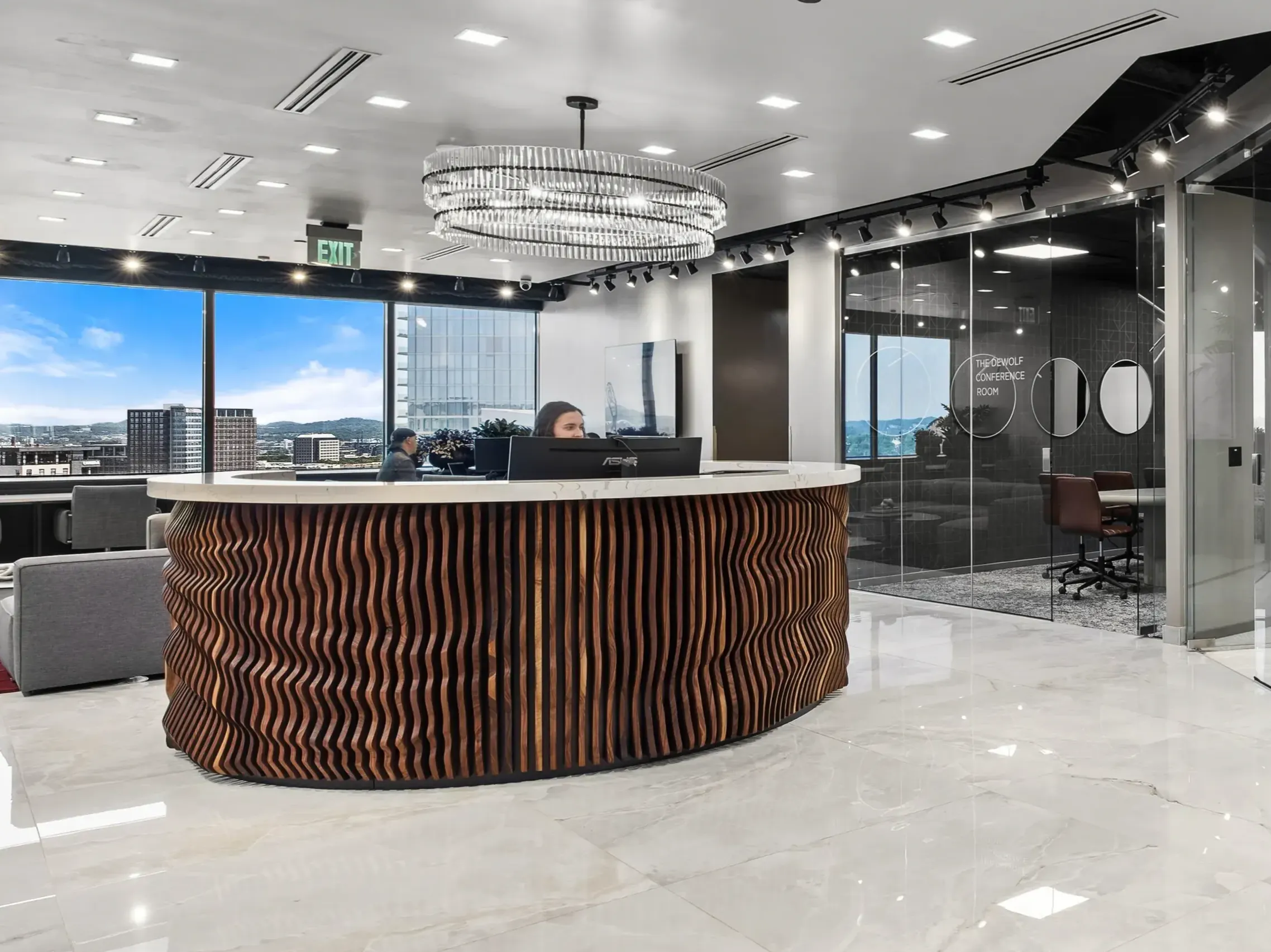Curved wood reception desk with downtown Nashville skyline view at Lucid Private Offices